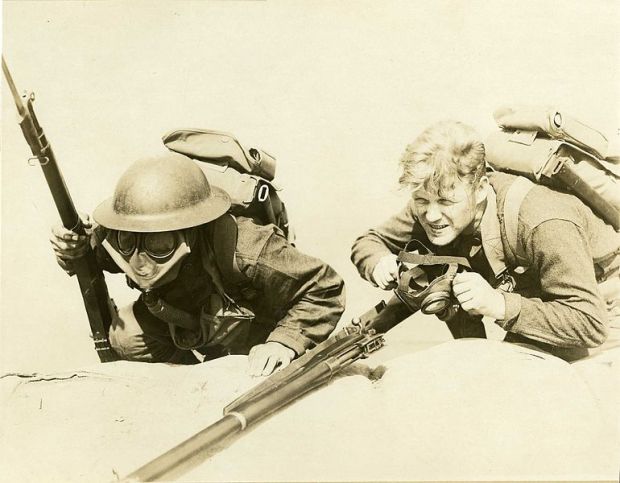 Photo pédagogique montrant deux soldats de la première guerre mondiale, l'un portant son masque à gaz, l'autre s'apprêtant à le mettre