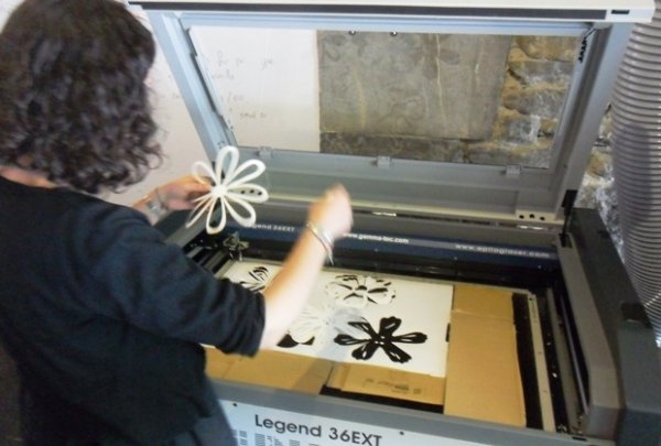 Stéphanie découpe ses fleurs de papier dans la découpeuse laser du FabLab de la Casemate
