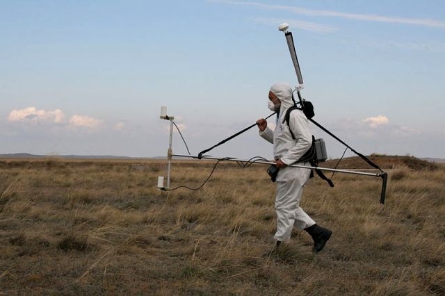 Transport d'un magnétomètre en vue de mesurer les déviations du champ magnétique terrestre afin d'identifier des cavités souterraines créées par une explosion nucléaire souterraine