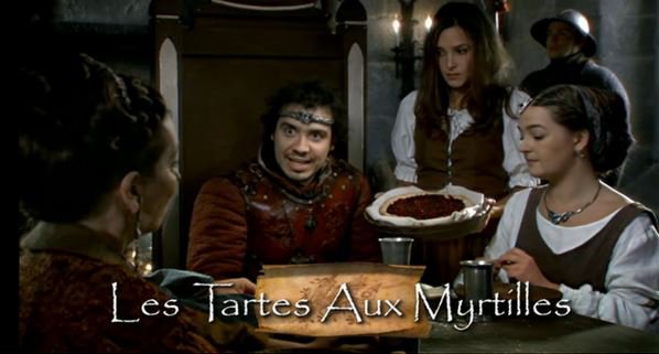 Image tiré de la série Kaamelott où on voit la reine Guenièvre et Arthur, en train d'essayer de manger une part de tarte à la myrtille. Ils font une drôle de tête